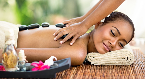 A Young Girl Experiencing Hot Stone Massage By a Professional Massage Therapist.